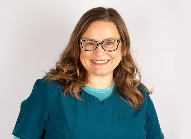 Dr. Kendra Zuercher smiling in teal dental attire
