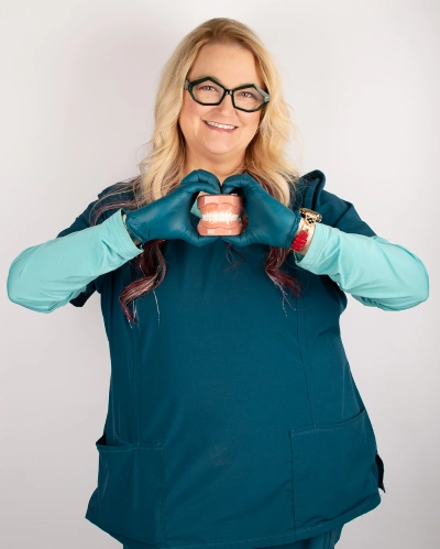 Dental team member smiling in teal dental attire