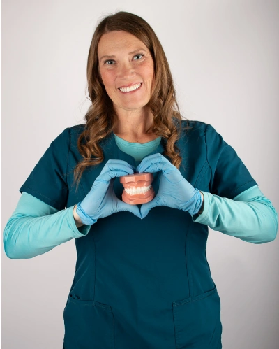 Dental team member smiling in teal dental attire