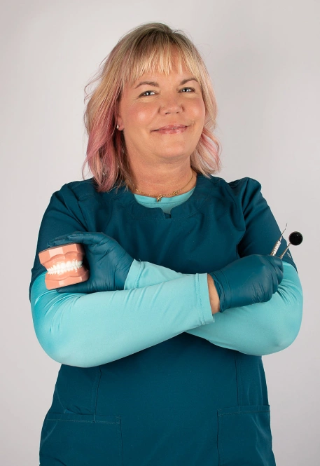 Dentist holding model teeth and dental tool, Designer Dentistry & Smiles, Sioux Falls, SD
